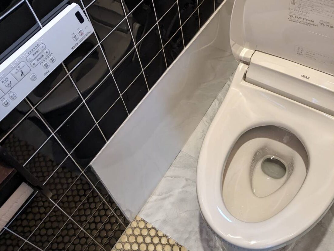 Sanitary worker performs repair of toilet bowl. To repair the pipe from the toilet