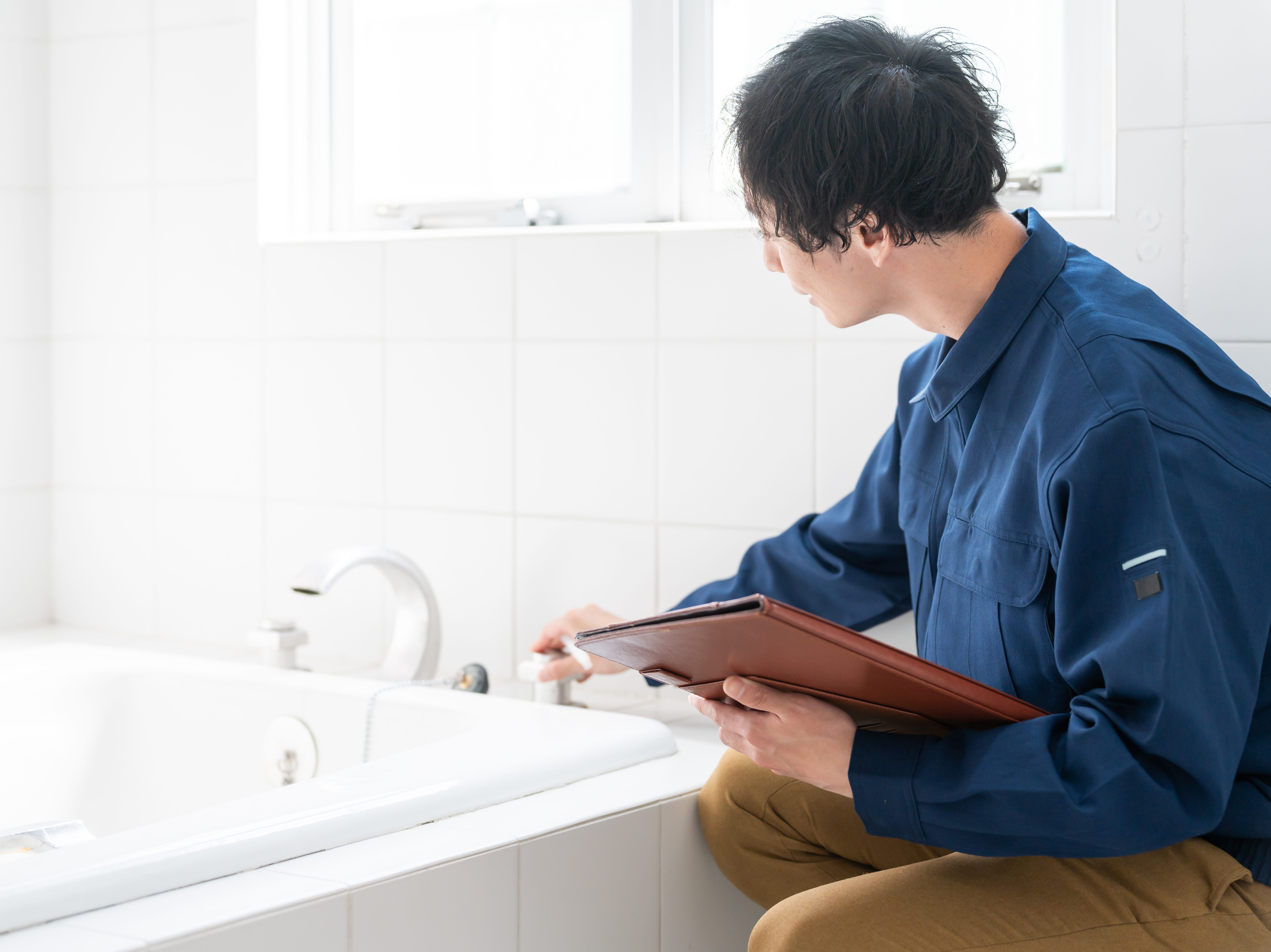 お風呂の水道を点検をする修理業者男性
